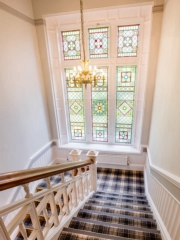 The stunning Victorian stained glass window creates beautiful light on the stair